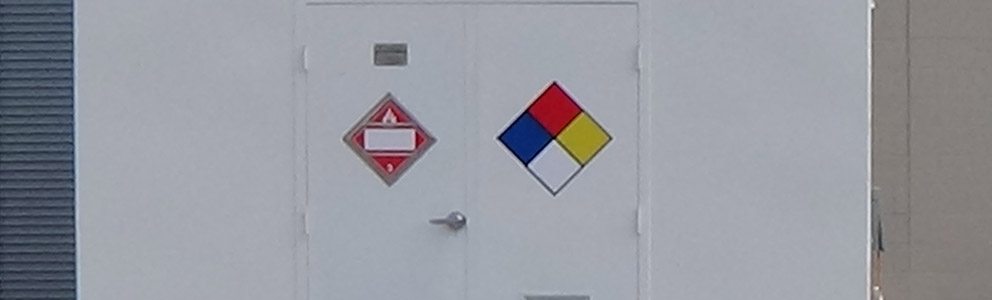 Doors of hazmat storage building marked with hazardous materials symbols