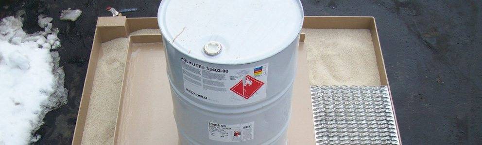 grease containment pad holding hazardous material barrel